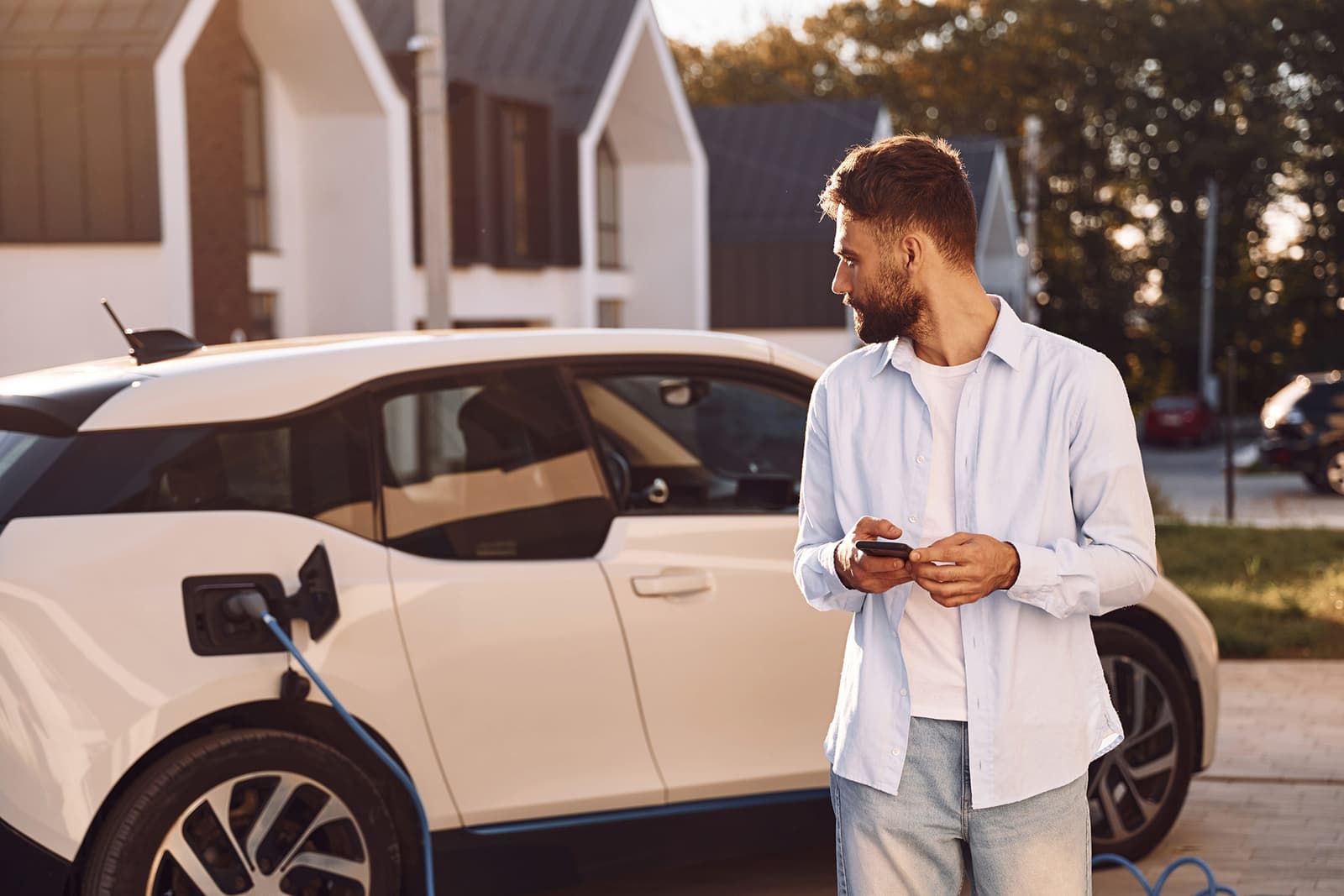 Person charging an electric vehicle at home